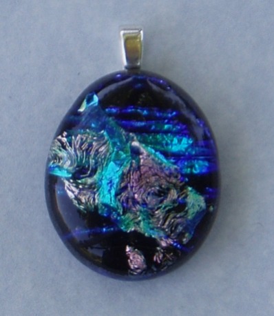 Silver, turquoise and cobalt dichroic glass over a black glass base. 7/8" wide by 1 1/8" long (excluding bail)